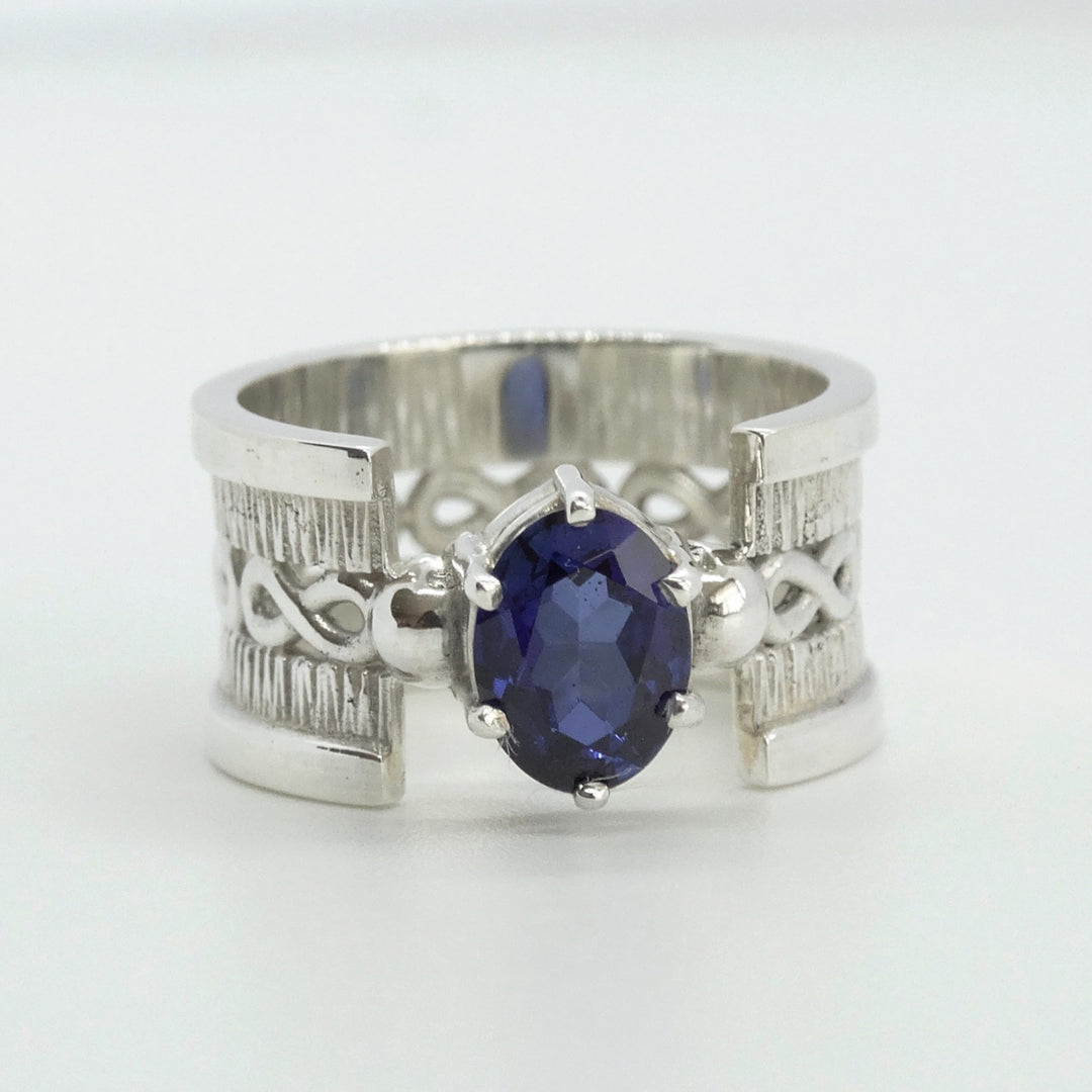 anillo de plata texturada con infinito y zafiro azul