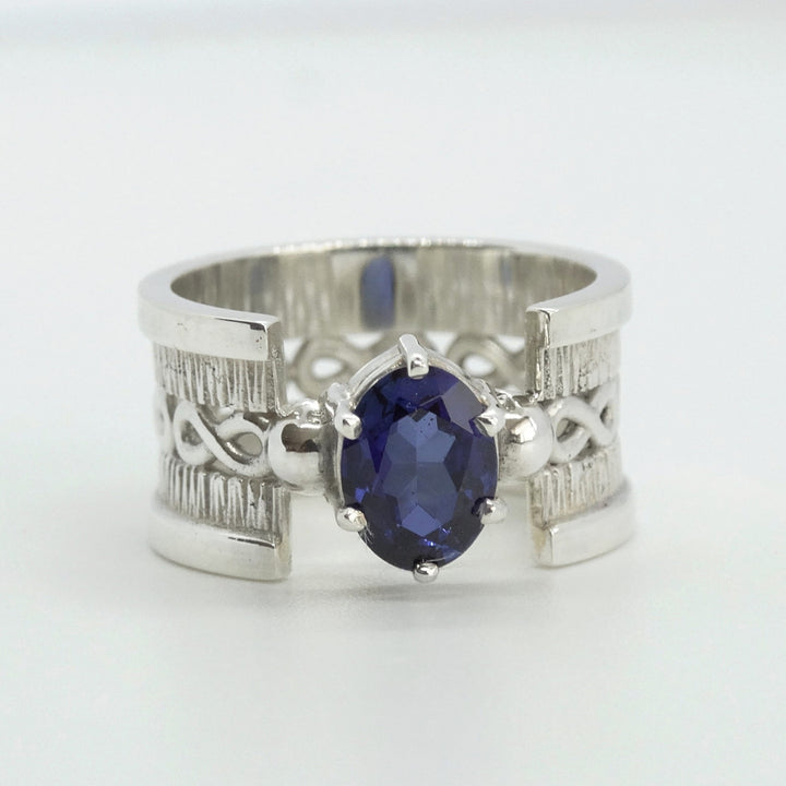 anillo de plata texturada con infinito y zafiro azul